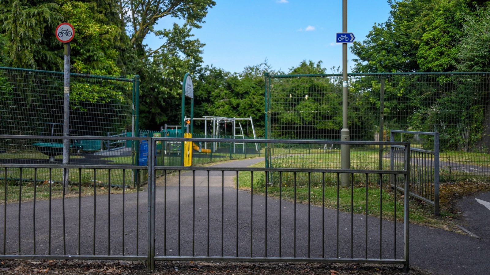 Enclosed children's play area with swings and climbing frames at Banbury Road Playground in Bicester.