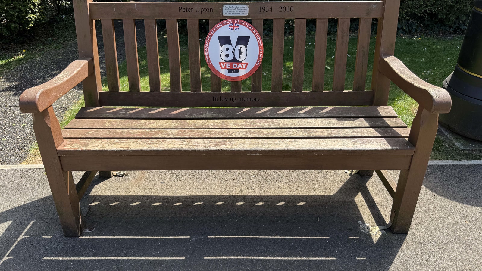 A secluded wooden park bench surrounded by mature trees in a quiet corner of Garth Park in Bicester