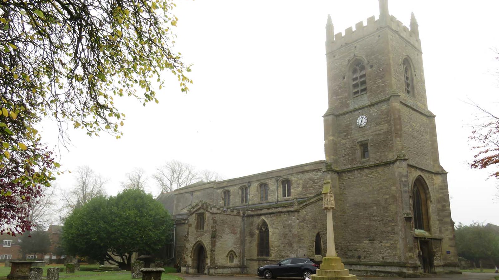 St Edburg's Church tower, nave, and churchyard War Memorial stone cross in Bicester.