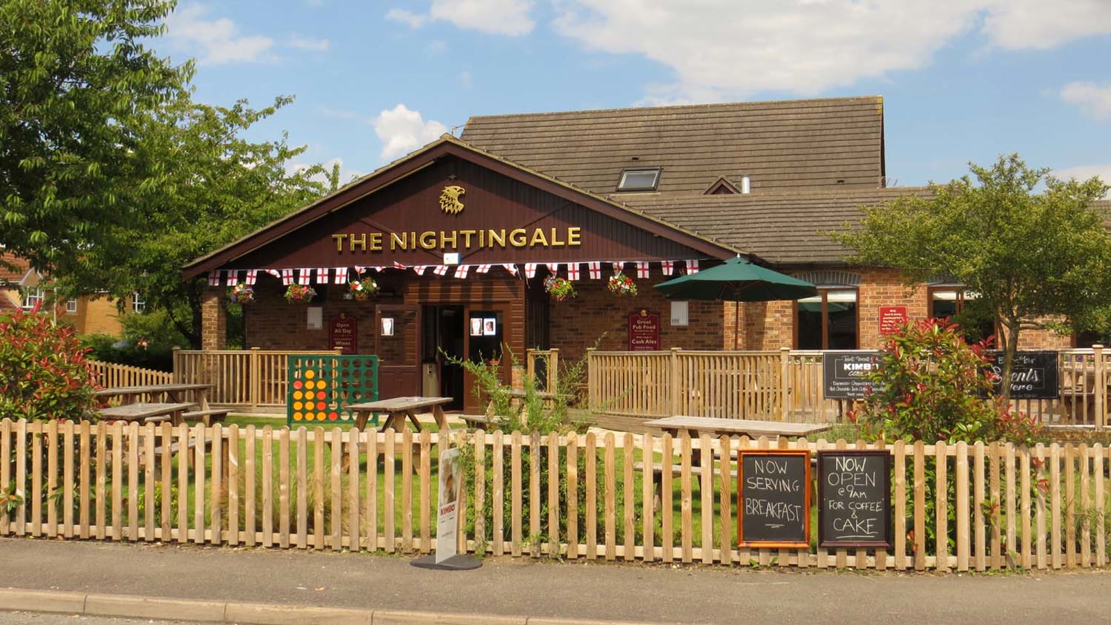 Exterior view of The Nightingale pub and outdoor beer garden seating on Peregrine Way in Langford Village.